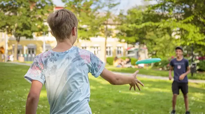 Två ungdomar kastar fresbee i en park